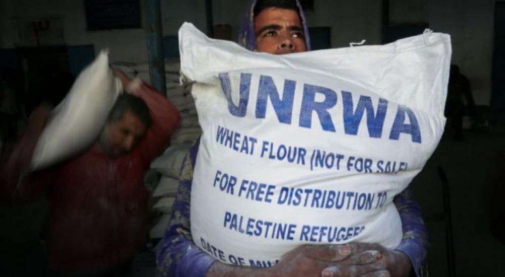 مواطن يحمل مساعدة من أونروا في غزة