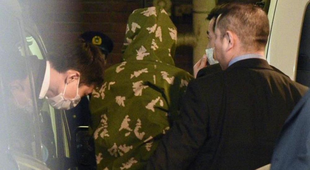 رجال أمن يقتادون ياسو ياماموتو (وسط) لحظة وصوله لتسليم نفسه لمركز شرطة وسط طوكيو