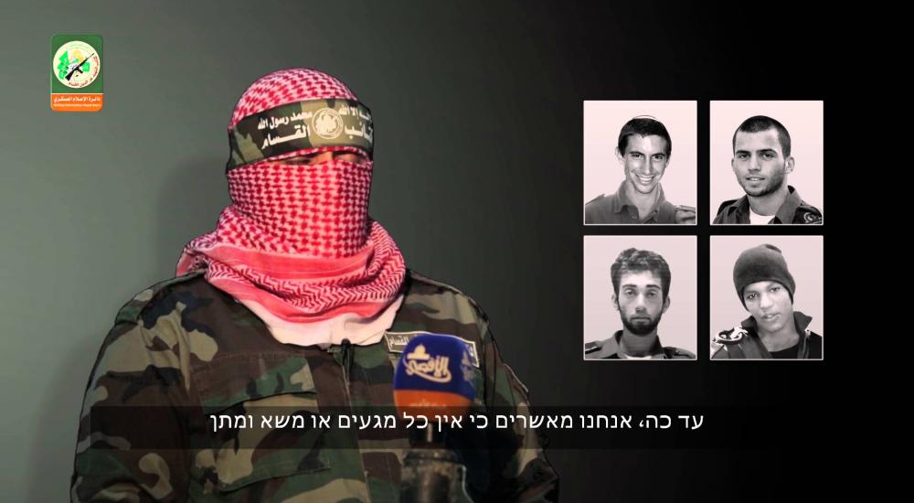 الناطق باسم القسام وفي الخلفية صور 4 جنود إسرائيليين أسرى