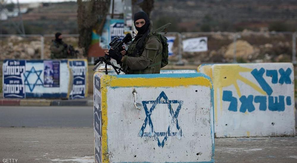 جندي إسرائيلي يقف خلف مكعب إسمنتي خوفًا من عمليات الدهس (أرشيف)