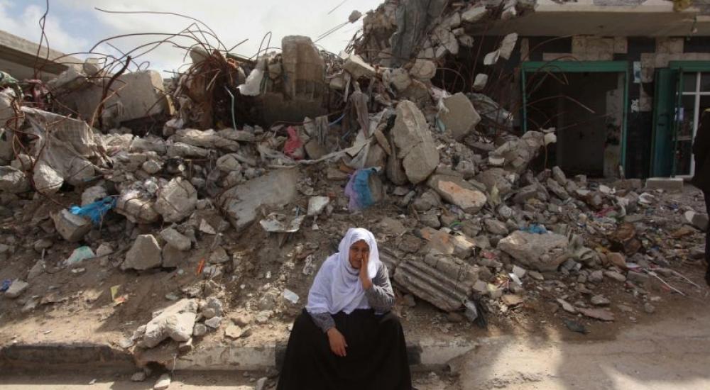 مواطنة تجلس أمام منزلها المدمر في قطاع غزة