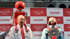 مطور الروبوت شيغينوري سوزوكي (يسار) أثناء عرضه "الطماطم المحمولة" في معرض إكسبو