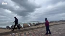 مواطنون يلتقطون صورًا تذكارية أثناء المنخفض الجوي من بحر غزة