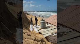 معتز برزق.. نازح من غزة يبني كوخًا من الرمل على ساحل بحر خان يونس ليعيش فيه بدلًا من خيمته البالية