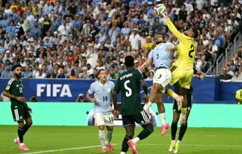 حارس السعودية محمد العويس يتصدى لهجمة من منتخب أوروجواي