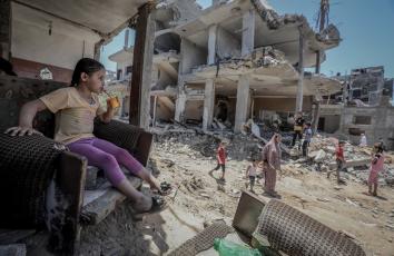 طفلة تجلس على ركام منزلها بعد أن دمر خلال الحرب الإسرائيلية على غزة - تصوير: محمد أسعد