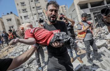 أب ينتشل جثمان أبنته من تحت ركام بمنزلهم - تصوير: محمد أسعد