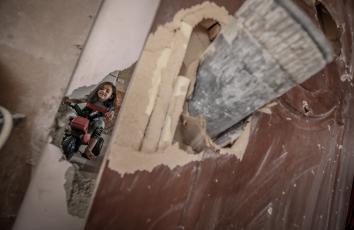 طفلة تلهو في غرفتها التي تعرضها للقصف بقذيفة إسرائيلية - تصوير: محمد أسعد