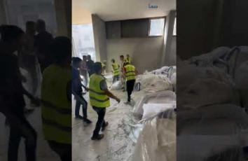 فلسطينيون يتسلمون طرودا من الدقيق بعد دخولها وتأمينها من أفراد العشائر