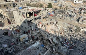 مواطنون يتفقدون المباني المتضررة بعد غارات على خان يونس جنوبي قطاع غزة