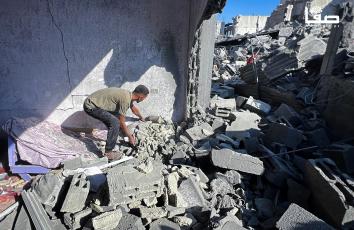 مواطنون يتفقدون منازلهم المدمرة بفعل القصف الإسرائيلي على مخيم النصيرات وسط قطاع غزة