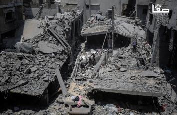 مواطنون يتفقدون مكان استهدف طائرات الاحتلال منازل في غزة