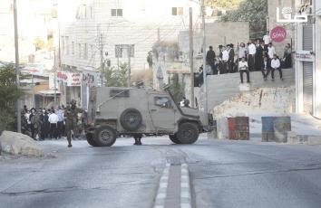 مستوطنون بحماية قوات الاحتلال يقتحمون منطقة باب الزاوية في مدينة الخليل بالضفة الغربية