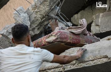 مواطنون يتفقدون آثار الدمار جراء القصف الإسرائيلي على منزل في شارع اليرموك بمدينة غزة