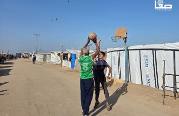 مواطنون يمارسون لعبة كرة السلة بين خيامهم في مواصي بخان يونس هربًا وتخفيفًا من آثار للحرب