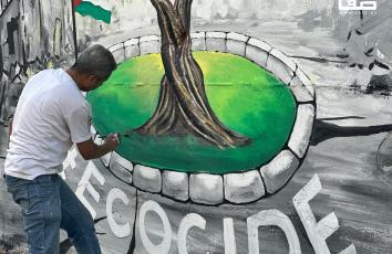 جدارية تجسد شجرة الزيتون وسط ركام المنازل في مدينة خان يونس جنوبي قطاع غزة