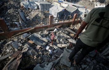 مواطنون يتفقدون آثار القصف الإسرائيلي على حي الزيتون في مدينة غزة