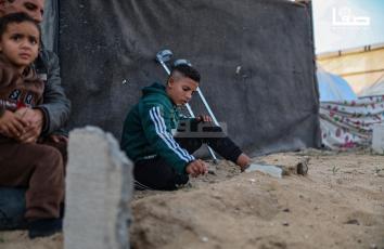 الطفل عمر (13 عامًا) يزور قبر ساقه المبتور خلال قصف إسرائيلي على عزة