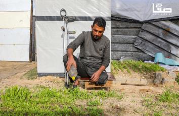 النازح محمد ناصر (44 عامًا) يتشبث بأرضه عبر الزراعة حول خيمته بعد أن فقد منزله وساقه خلال حرب الإبادة على قطاع غزة