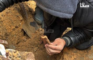 المواطن أبو إسماعيل حماد (45 عامًا) يبحث عن رفات عائلته مستخدمًا مجرفةً وفأسًا ومنخلًا في حي الصبرة بمدينة غزة