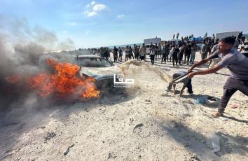 محاولات إخماد النيران التي اندلعت في مركبة قصفها الاحتلال الإسرائيلي في محيط البيدر جنوب غربي مدينة غزة