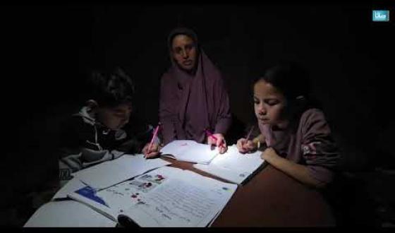 أم تُدرّس أطفالها وأيتام شقيقها تحت ضوء مصباح في خيمة النزوح بمواصي خان يونس جنوبي قطاع غزة